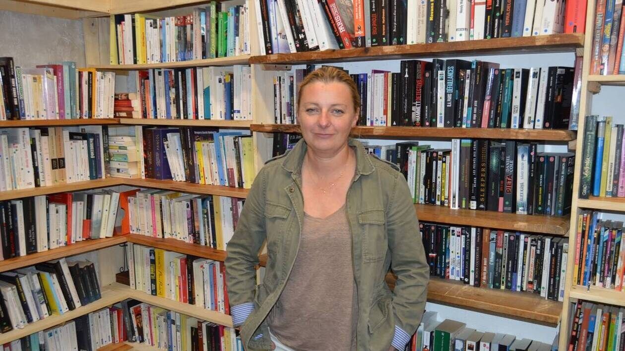 Portrait de Fabienne Bainée devant des livres