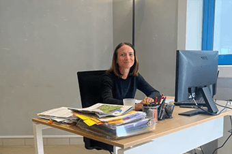 Femme souriant devant un ordinateur de bureau